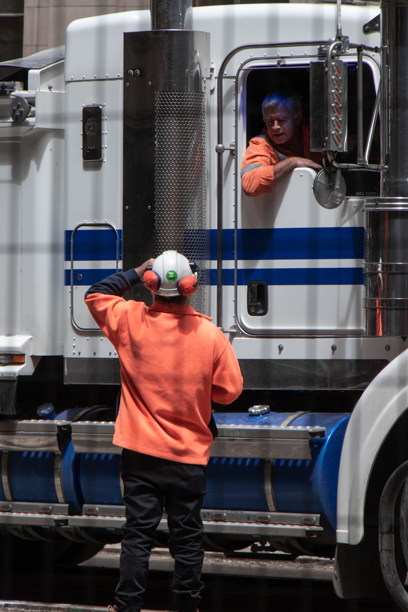 man performing commercial vehicle inspections standing in front of freight truck